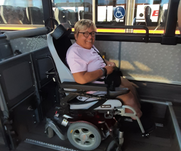 A woman in a wheelchair is sitting on a bus