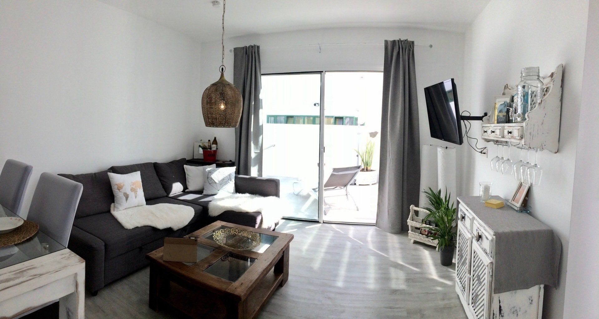 A living room with a couch , table , chairs and television.