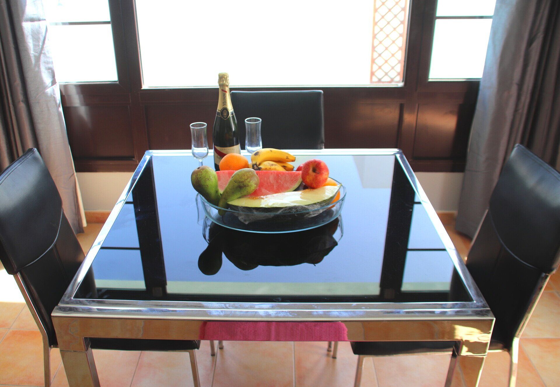 A dining room table with a bowl of fruit on it