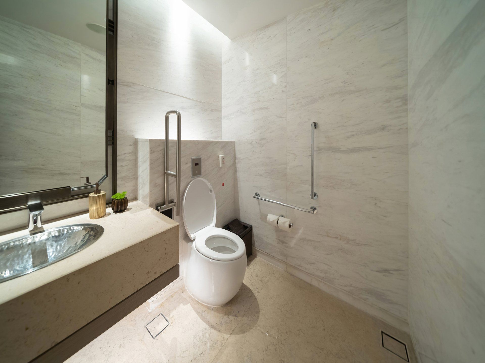 A bathroom with a toilet , sink and mirror.