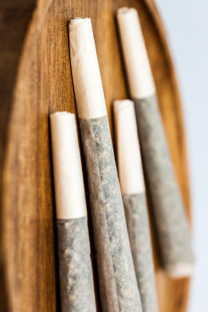 A group of cigarettes are sitting on top of a wooden tray.