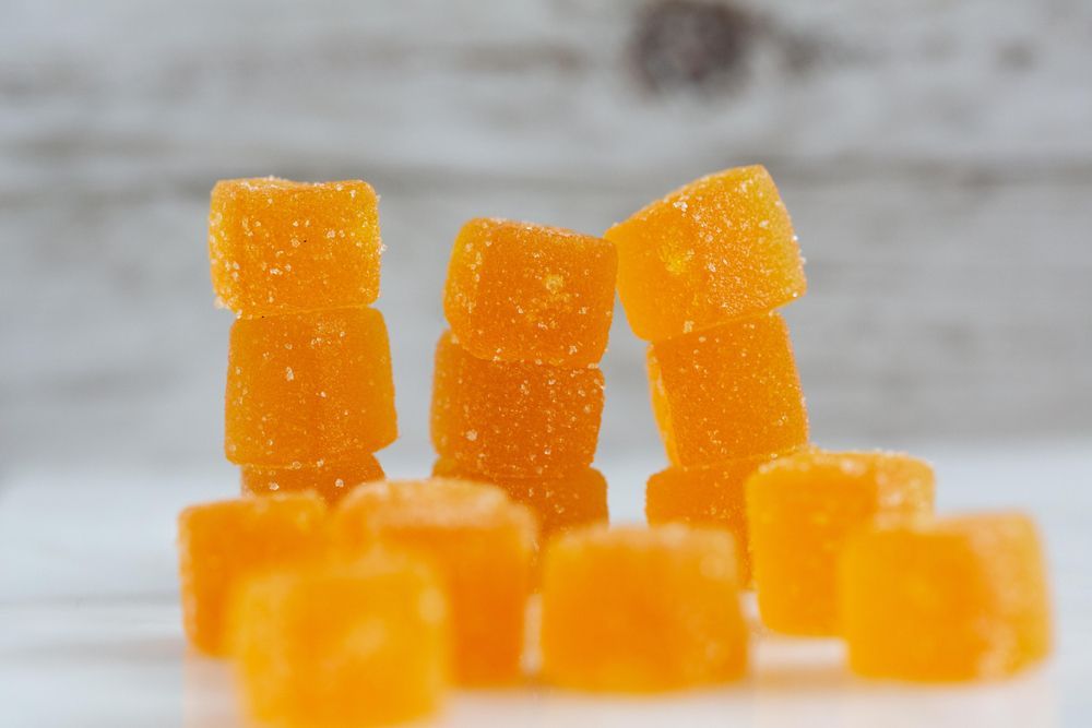 A pile of orange gummy bears stacked on top of each other on a table.