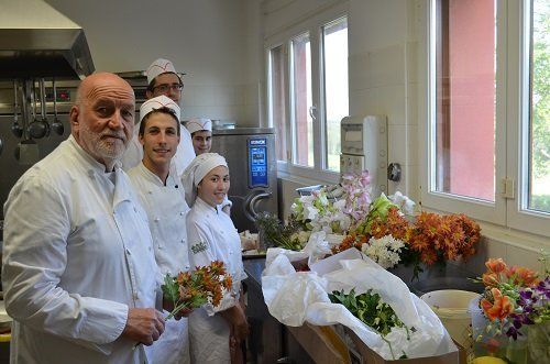 staff wearing white chef coats working with colored flowers