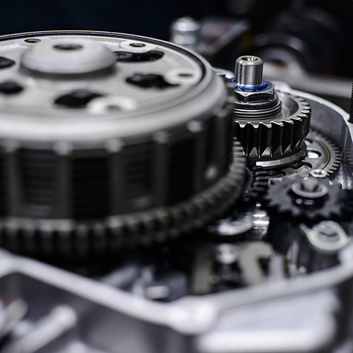 Close-up of motorcycle engine components: gears, clutch, and housing.