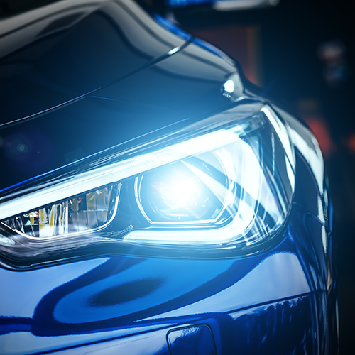 Blue car headlight, illuminated.