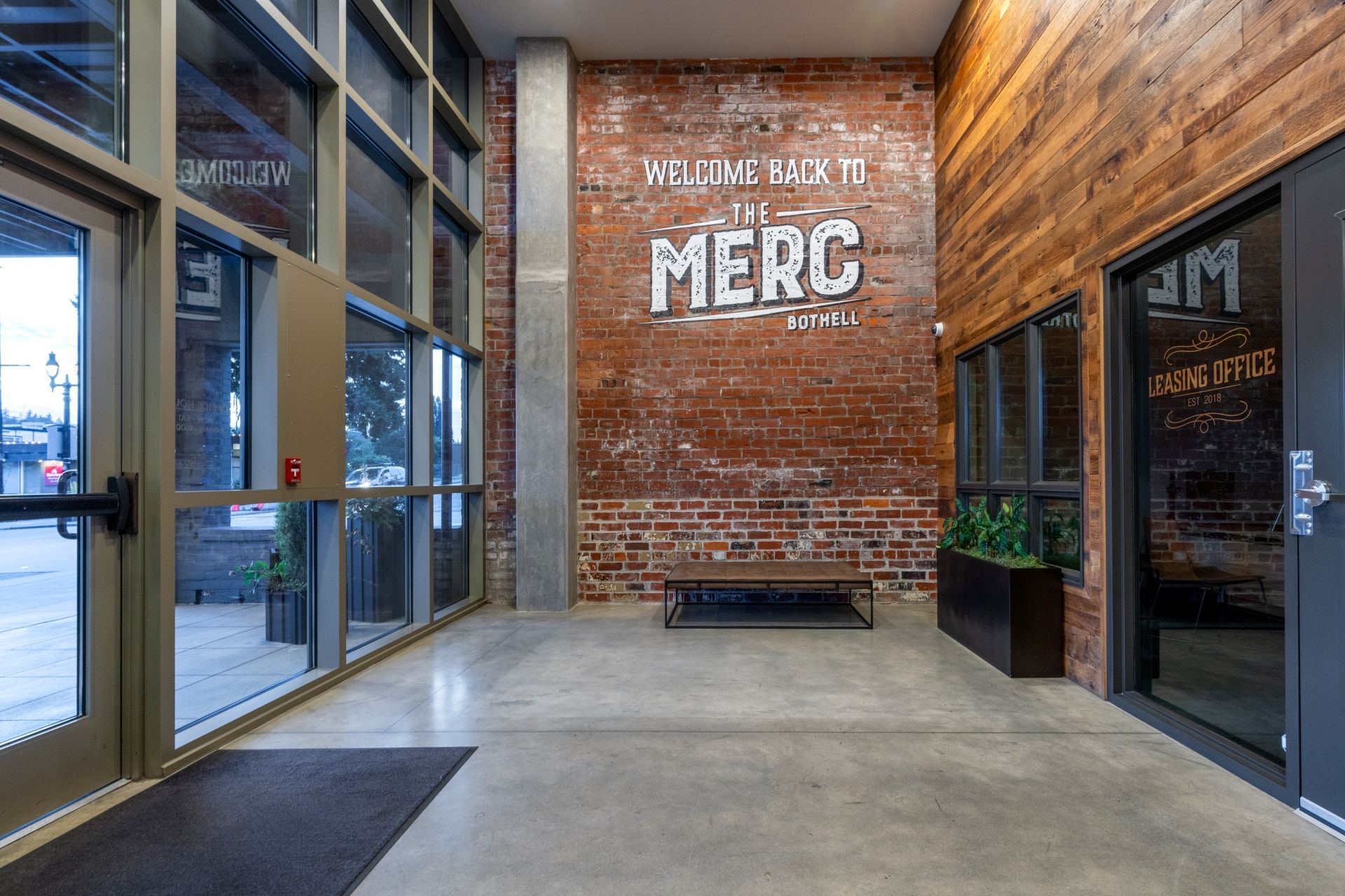A large lobby with a brick wall and a sign that says merg.