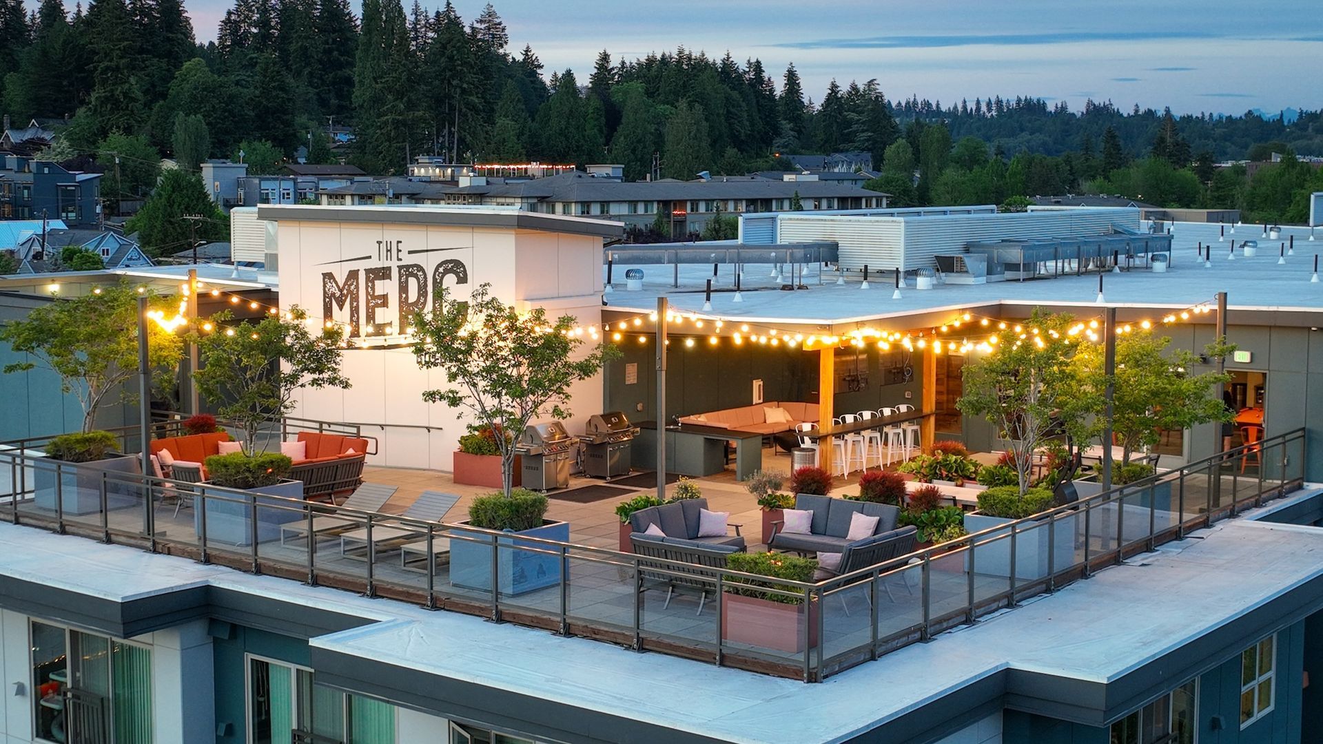 Rooftop patio with string lights, seating, and a bar area at Merc restaurant.