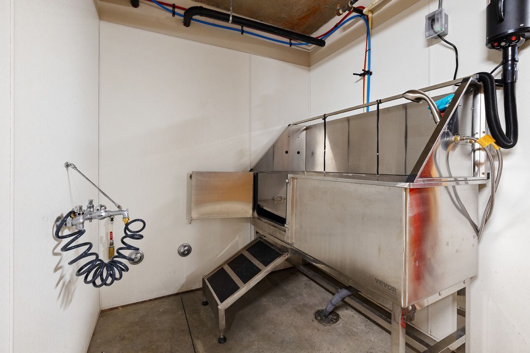 There is a stainless steel dog bathtub in the middle of the room.