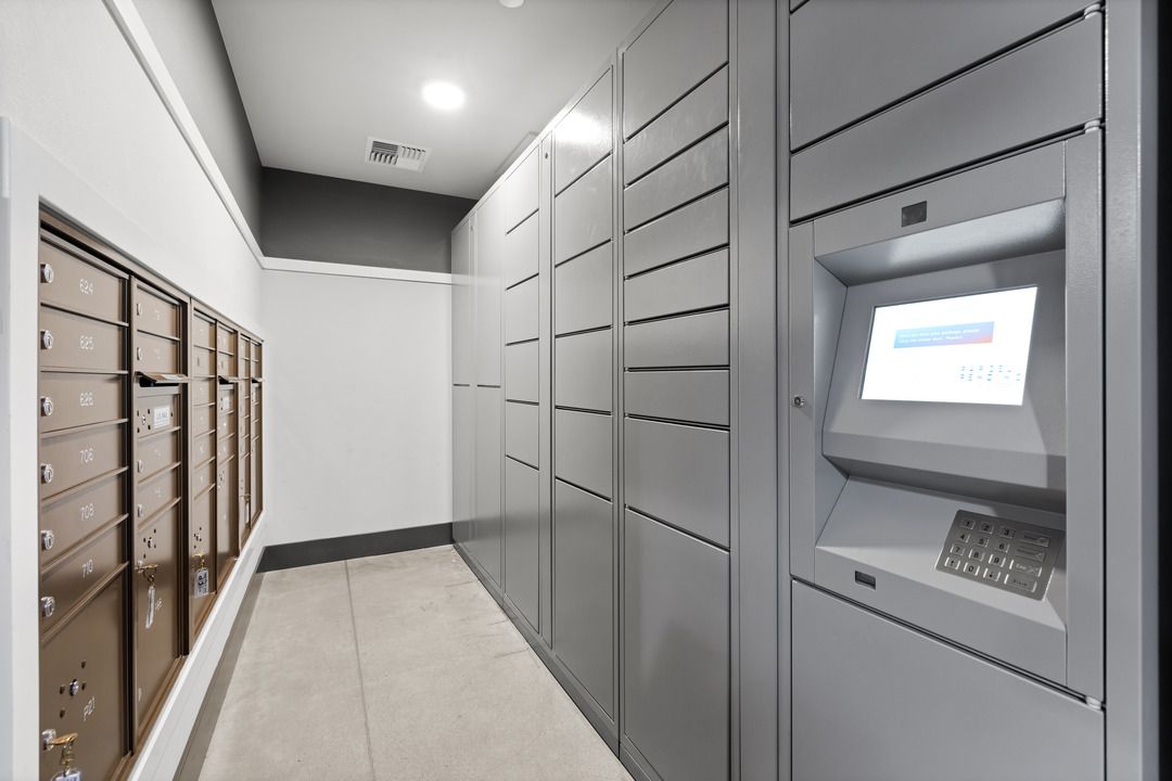 A hallway with a lot of mailboxes and a machine on the wall.