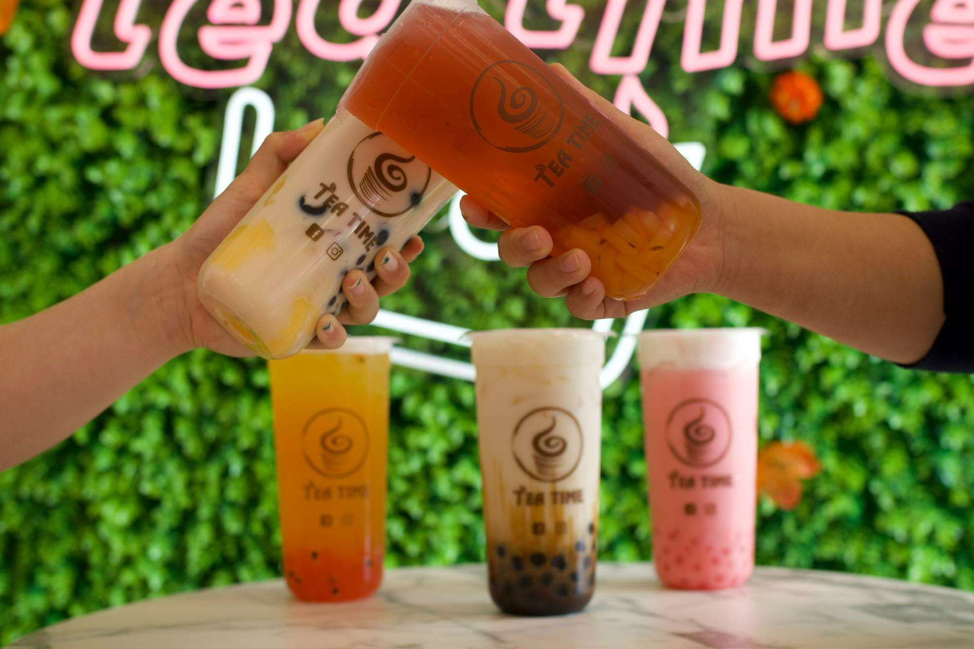 A group of people are toasting with their drinks in a restaurant.