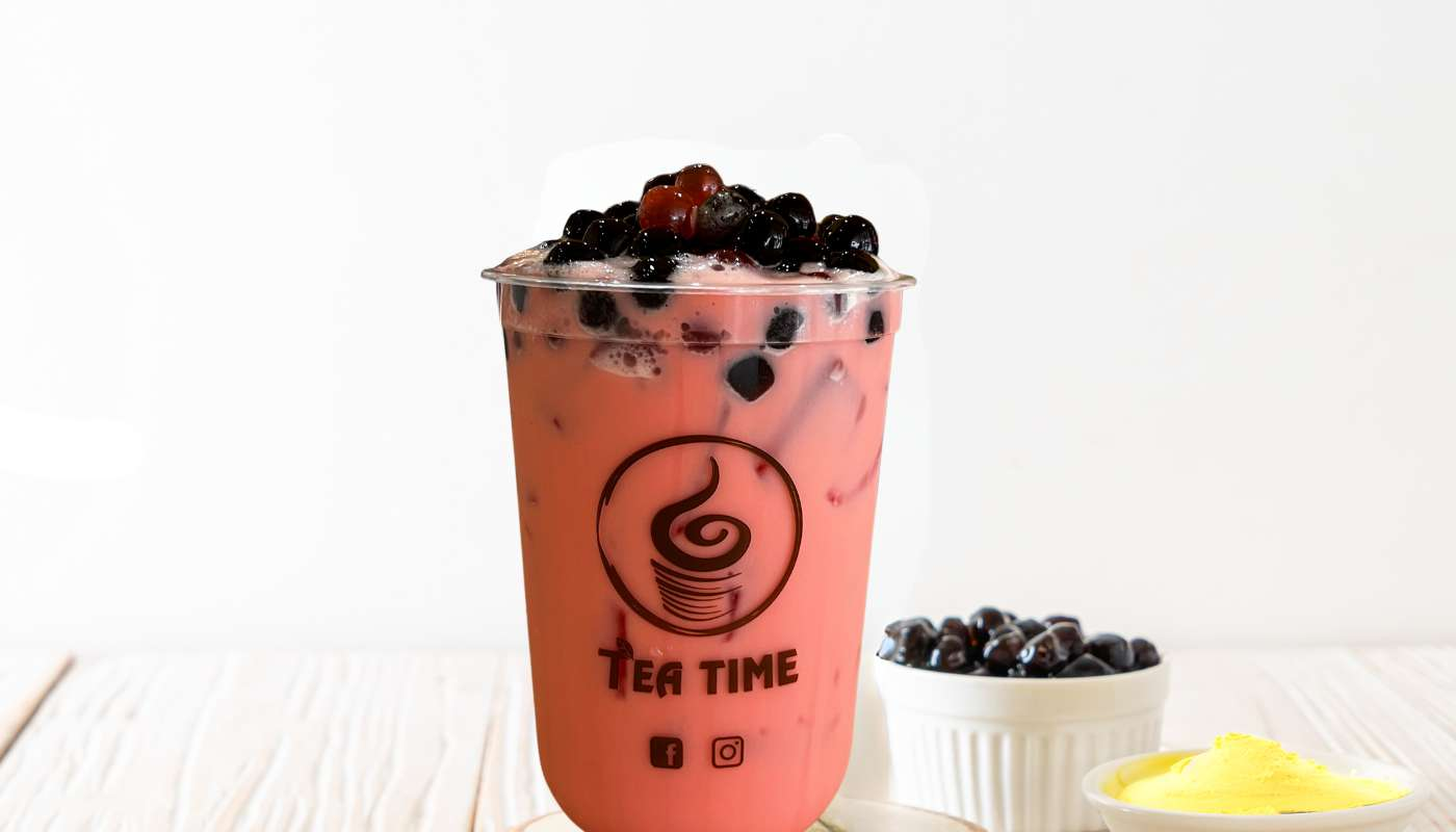 A cup of tea with bubbles on top of it is on a table.