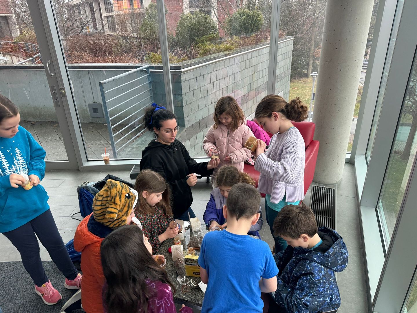 A group of children are sitting around a table in a room.