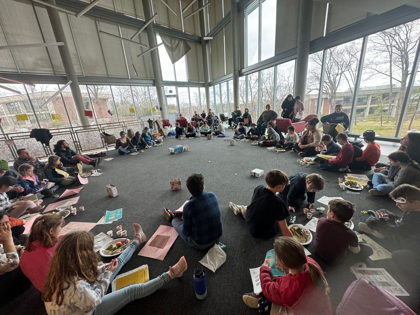 A group of people are sitting in a circle on the floor in a room.