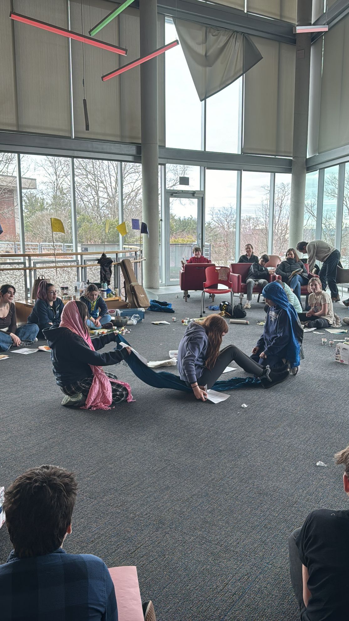 A group of people are sitting on the floor in a room.