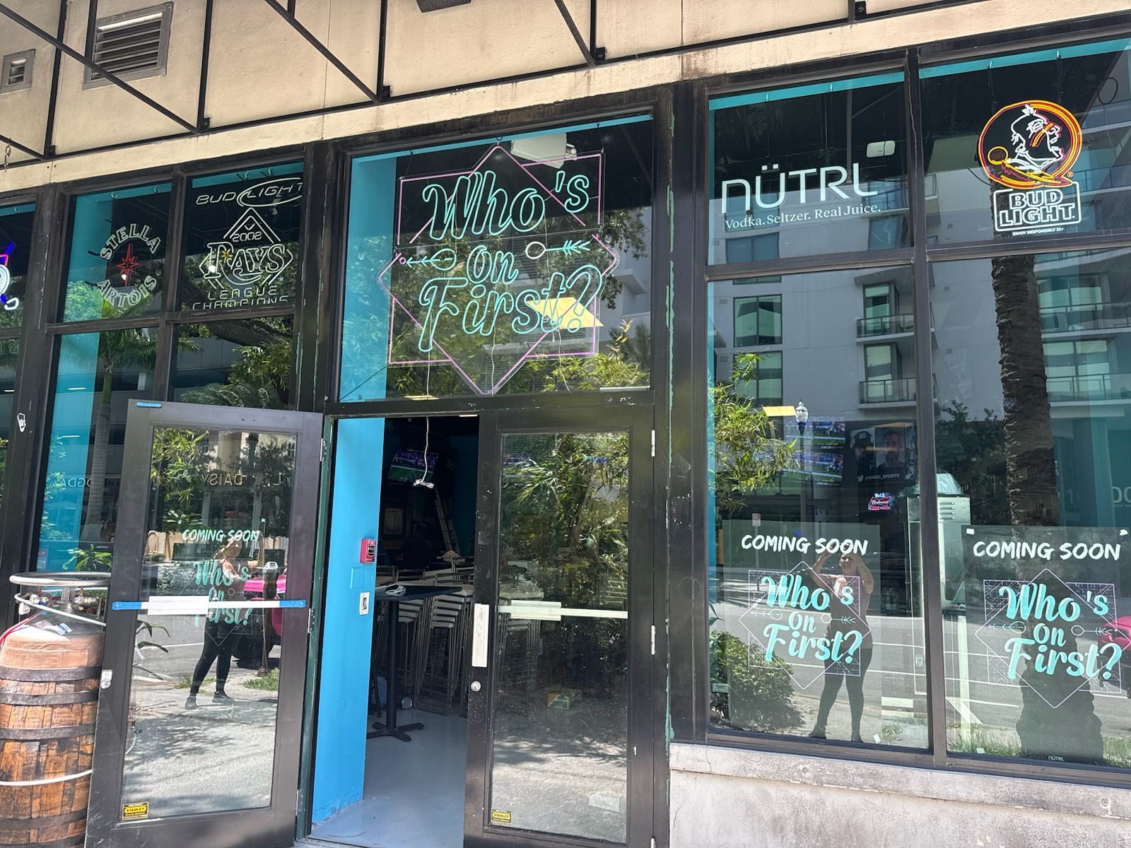 The outside windows and door of the restaurant with signs saying Coming Soon