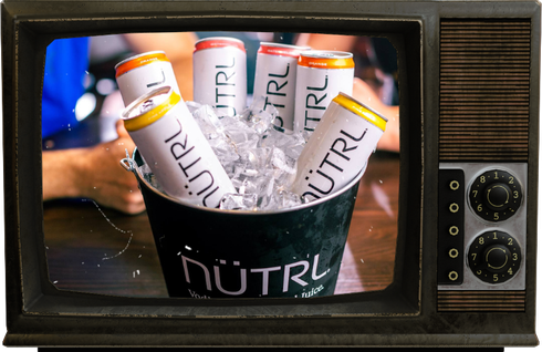 A tv screen shows a bucket of ice and cans of Nutrl malt beverage