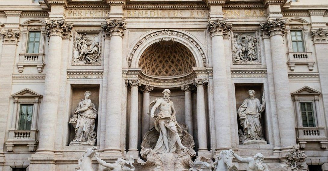 The Trevi Fountain in Rome featuring the central statue of Oceanus surrounded by classical columns and ornate sculptures.