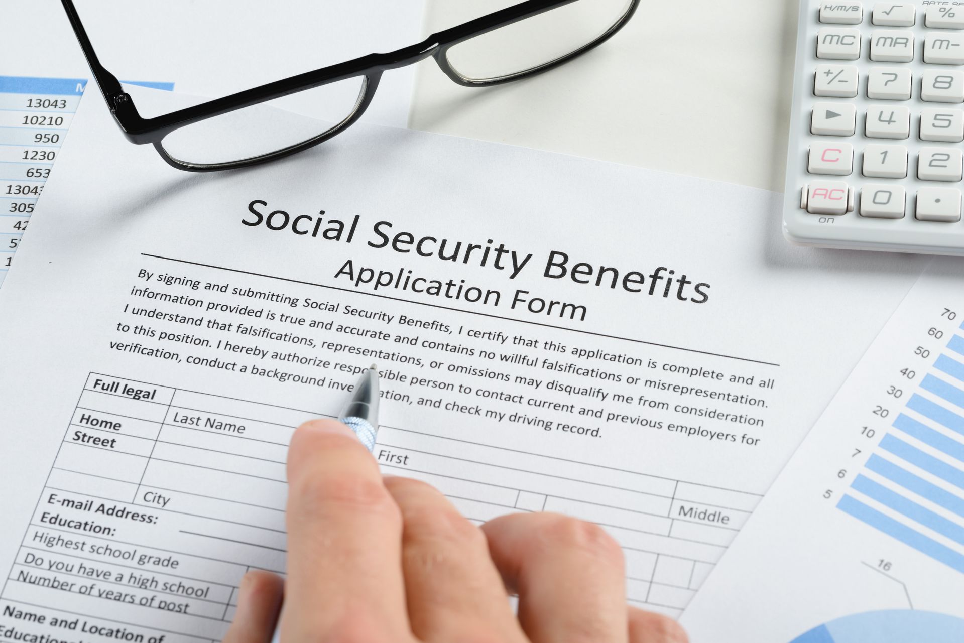 A person is filling out a social security benefits application form