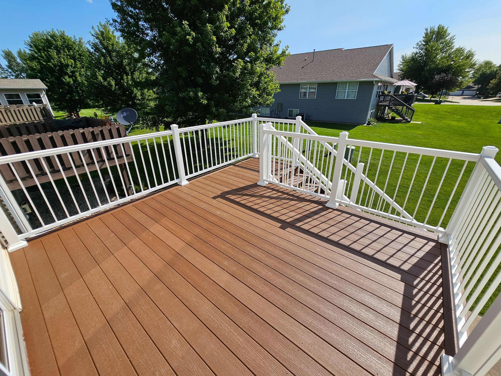 Brown composite deck with white hand rails in Marion Iowa