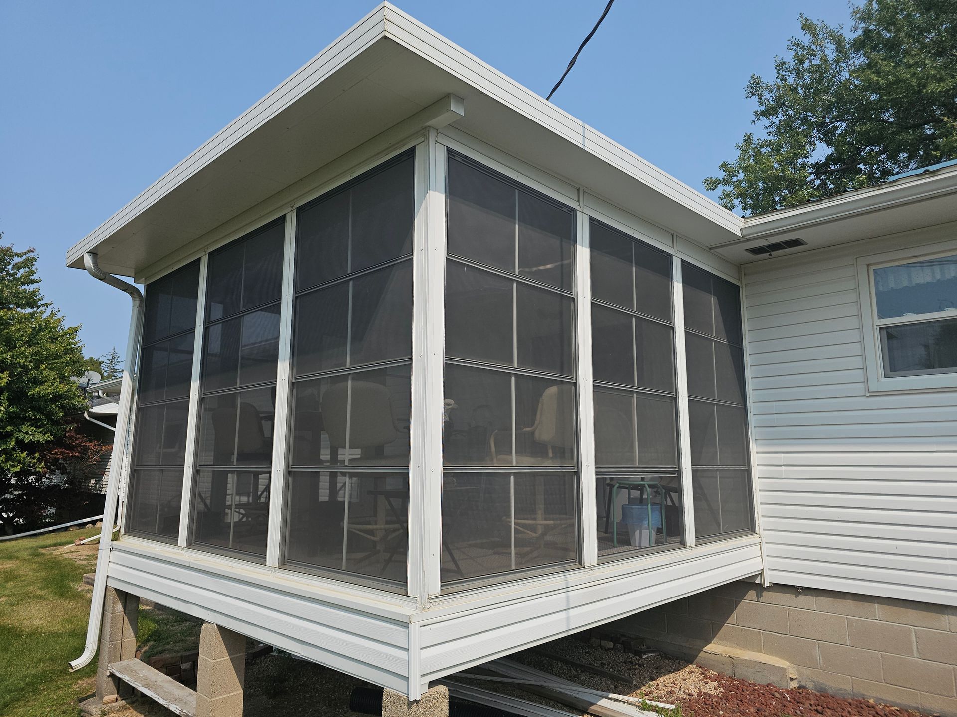 Original screened-in porch with open panels and exposed framing