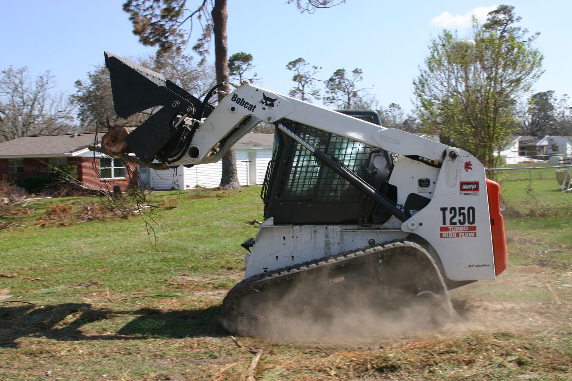 A bobcat t250 is driving through a grassy field