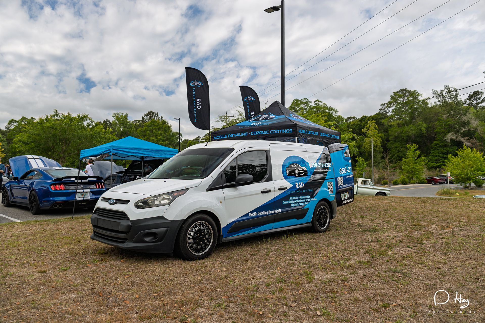RydrDie Auto Detailing mobile detailing van and branded booth setup displayed at a local car show wi