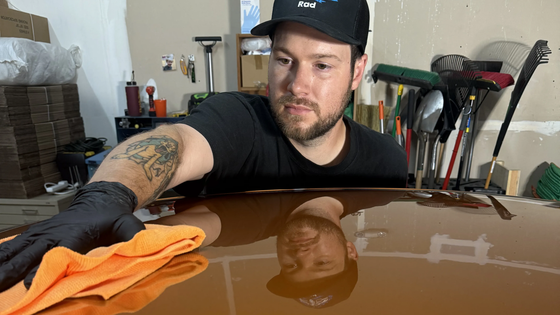 Reflection photo of a detailer in the freshly paint-corrected and ceramic-coated roof of a 2006 Pontiac GTO.