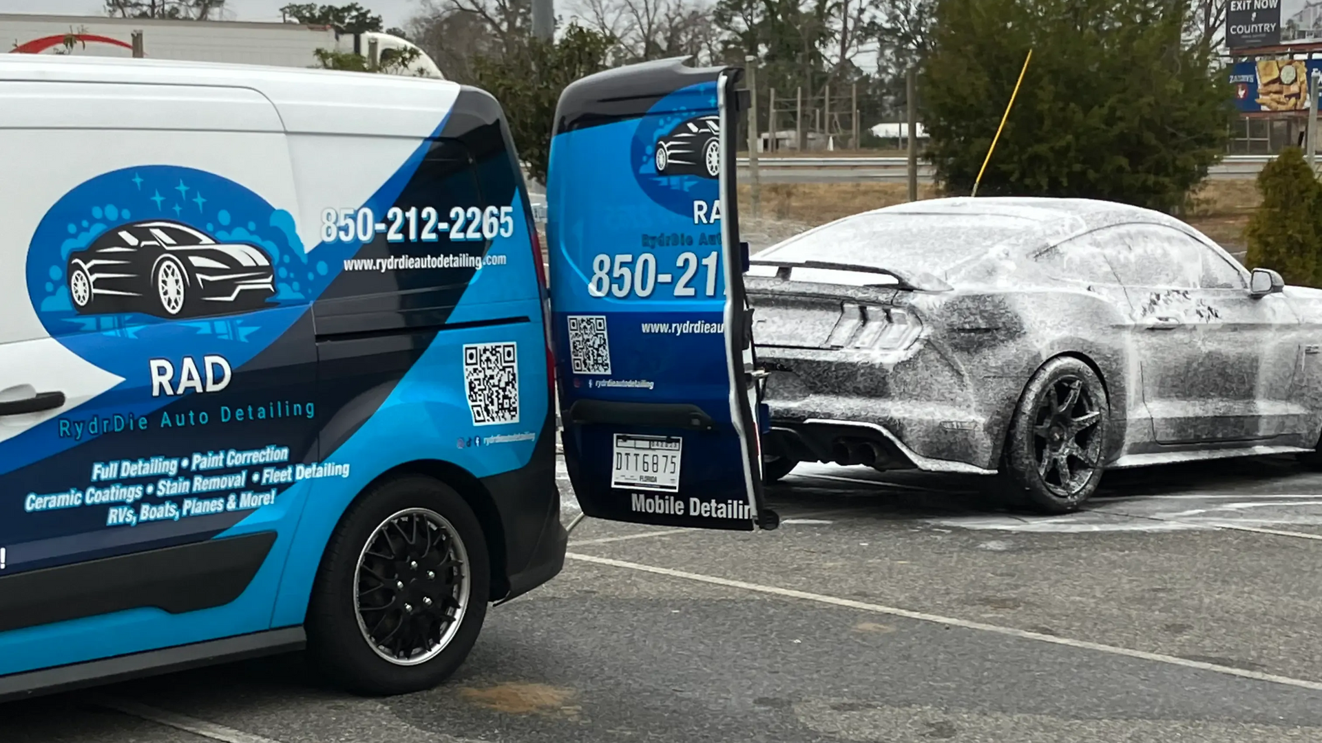 Professional mobile detailing van servicing a Ford Mustang in Tallahassee, FL with exterior wash!