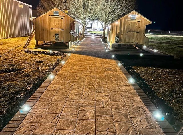 Stone retaining wall along a road, with construction debris, cones, and hillside.