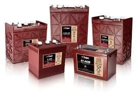 Cinco baterías Trojan de ciclo profundo, de color marrón, con terminales blancos sobre fondo blanco.