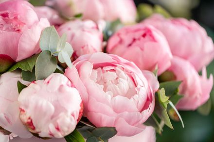 A basket filled with flowers is sitting on a wooden table.