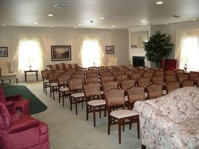 A living room with a couch , chairs , and a coffin.