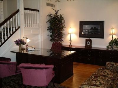An artist 's impression of a hotel lobby with a couch , chairs , and plants.