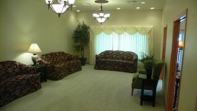 The front door of a house with a porch and plants in front of it.