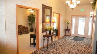 An artist 's impression of a hotel lobby with a couch , chairs , and plants.