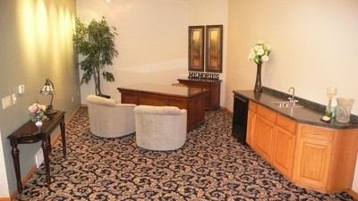 A living room with a couch , chairs , and a coffin.