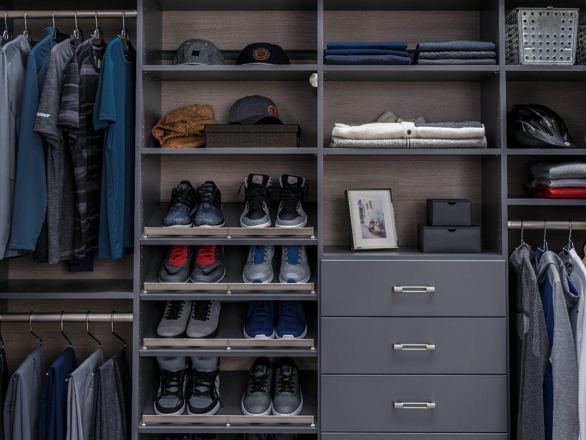 A reach in closet filled with lots of clothes and shoes