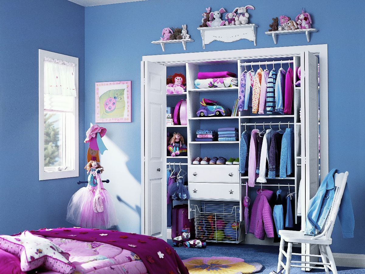 A girl 's bedroom with blue walls and a closet full of clothes