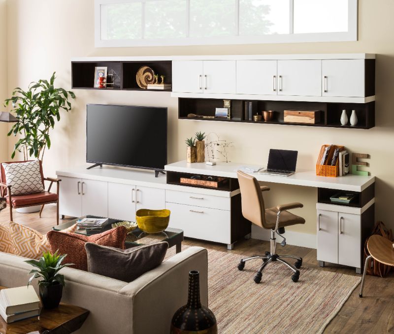 A living room with a desk and a flat screen tv.