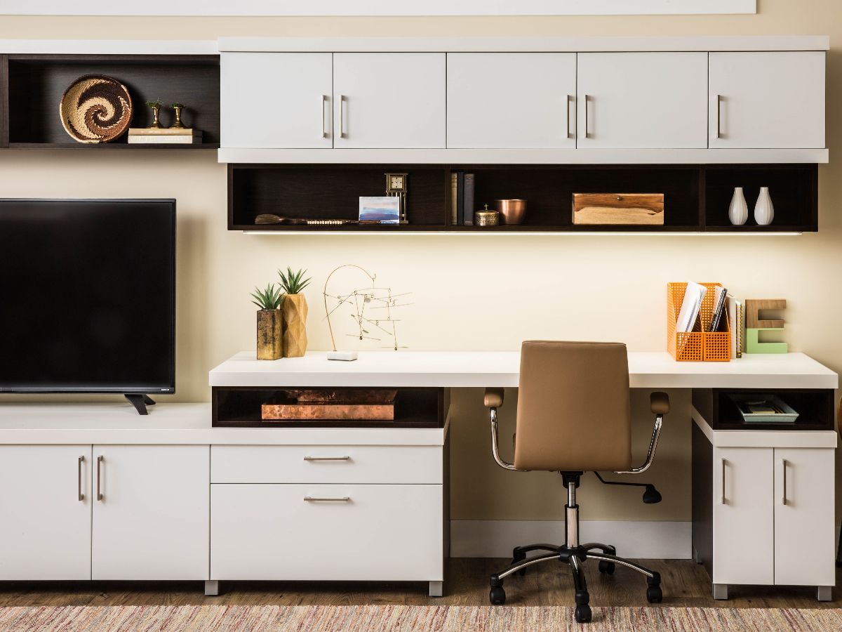A desk with a chair and a flat screen tv on it