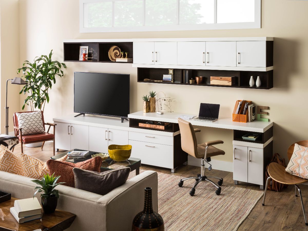 A living room with a couch , desk , chair and television.