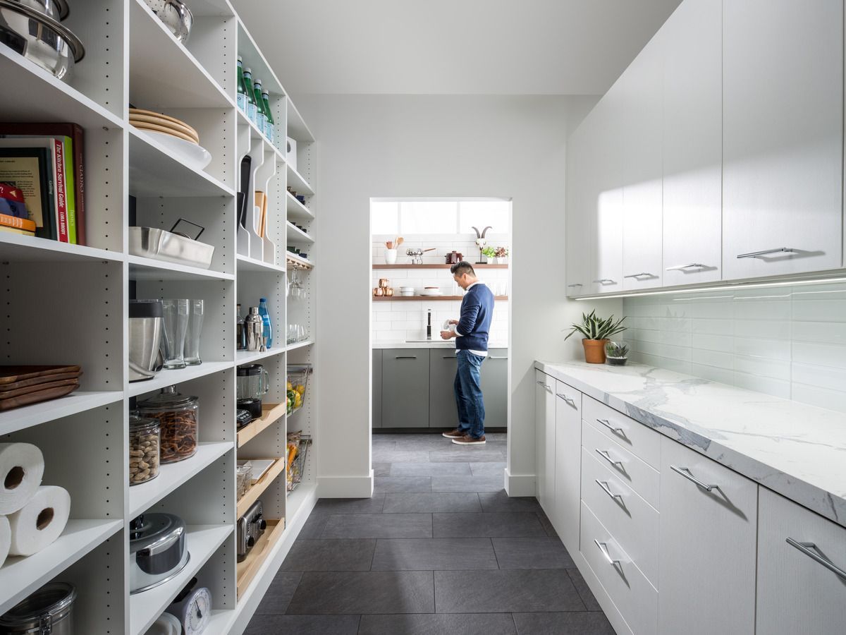 A man is standing in a kitchen in a pantry.