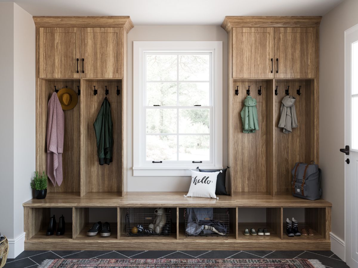 A wooden bench with a pillow and baskets in a hallway.