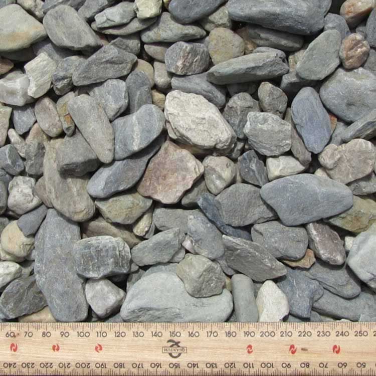 Close-up of a Pile of Gray River Rocks With a Ruler for Scale — Kuranda Landscape Supplies in Kuranda, QLD