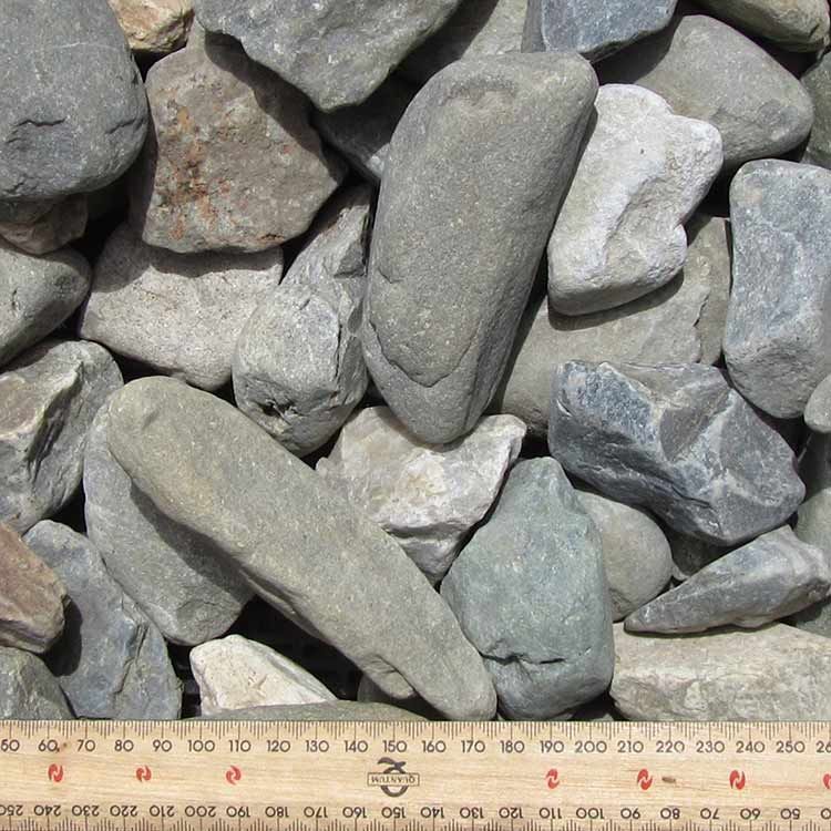 Pile of Gray River Rocks of Varying Sizes, Next to a Ruler for Scale — Kuranda Landscape Supplies in Kuranda, QLD