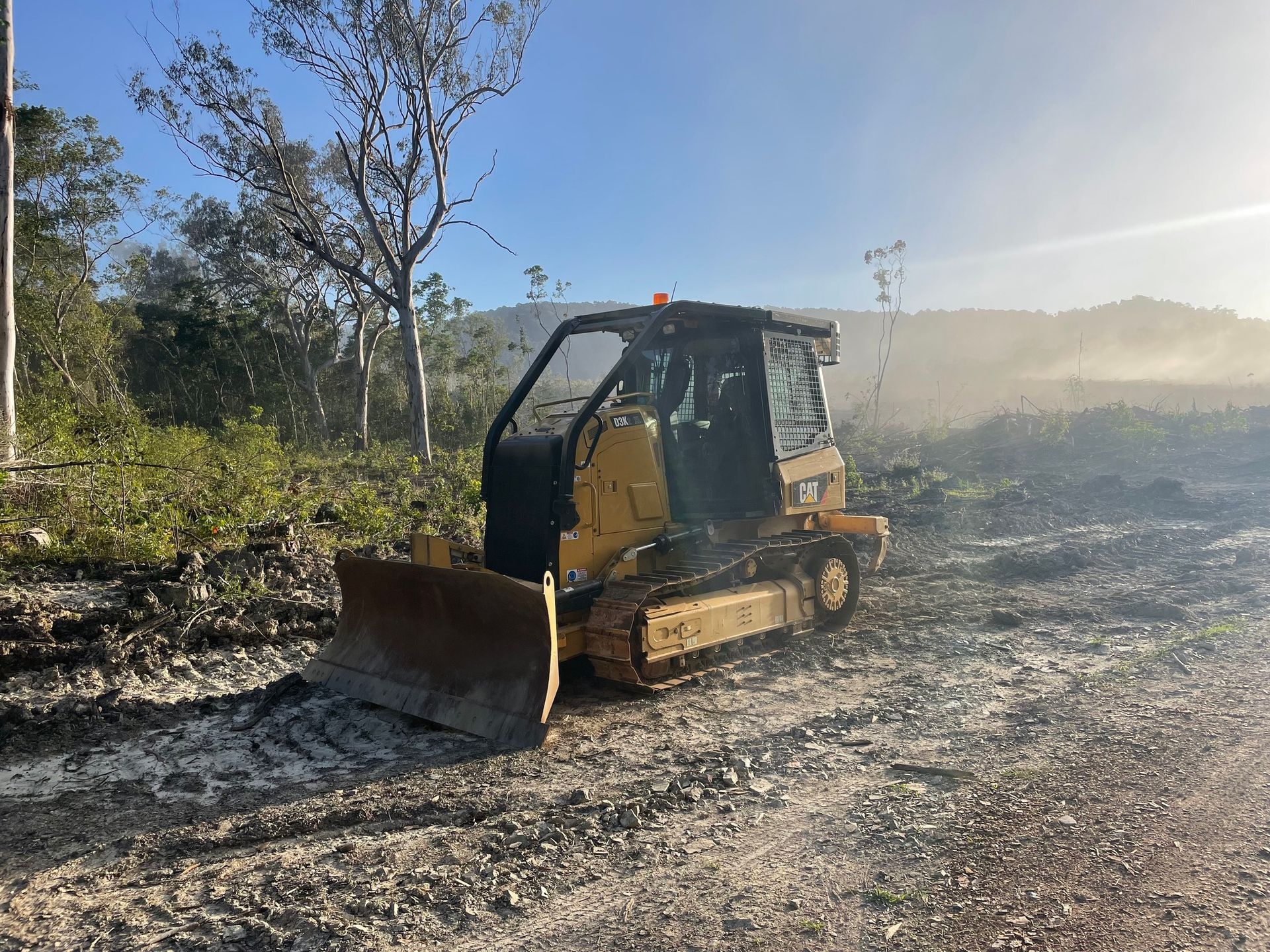 Yellow Caterpillar Bulldozer Clearing Land, Sunny Day — Kuranda Landscape Supplies in Kuranda, QLD