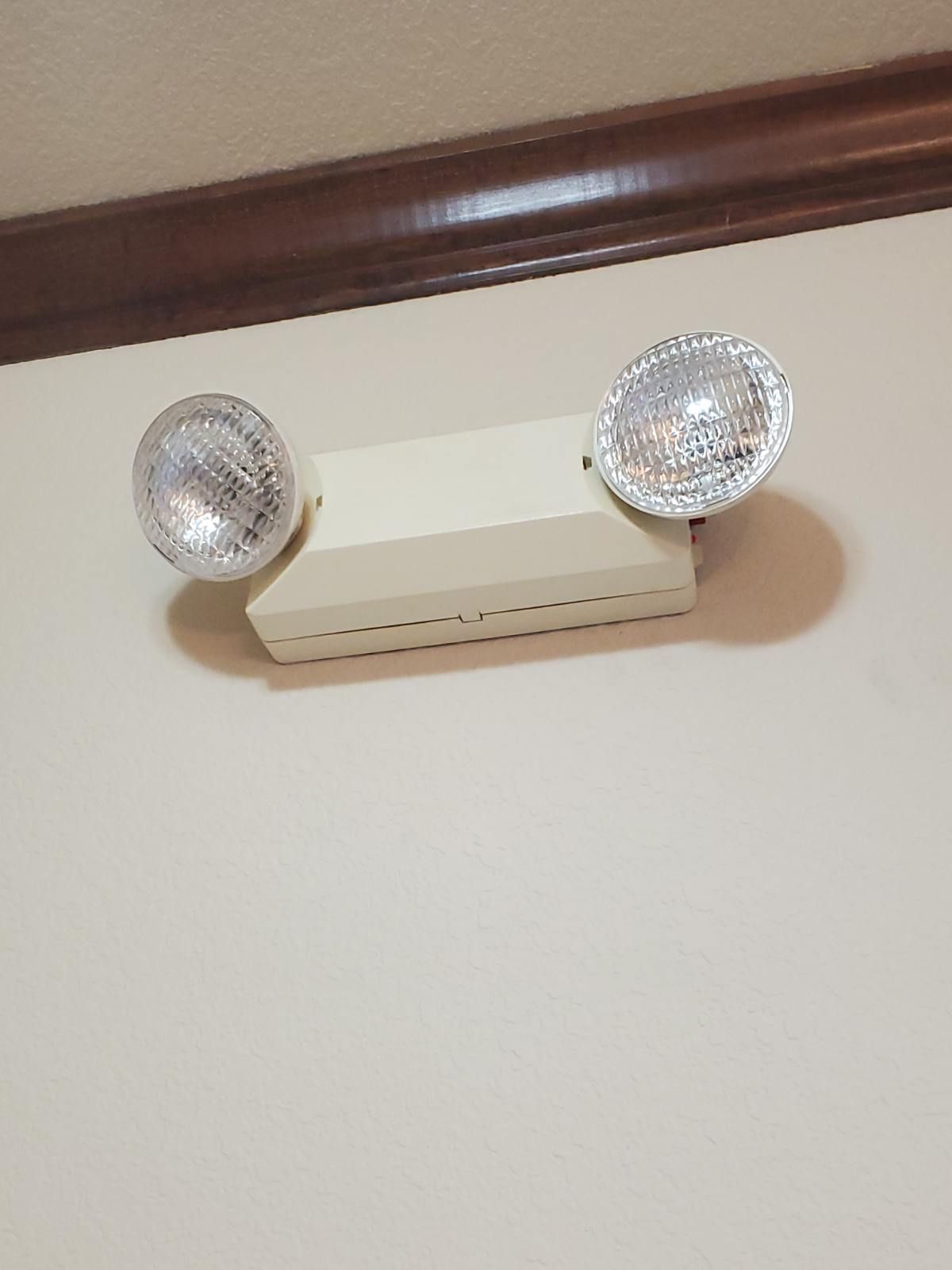 Hand squeezing the handle of a red fire extinguisher, likely for testing or practice.