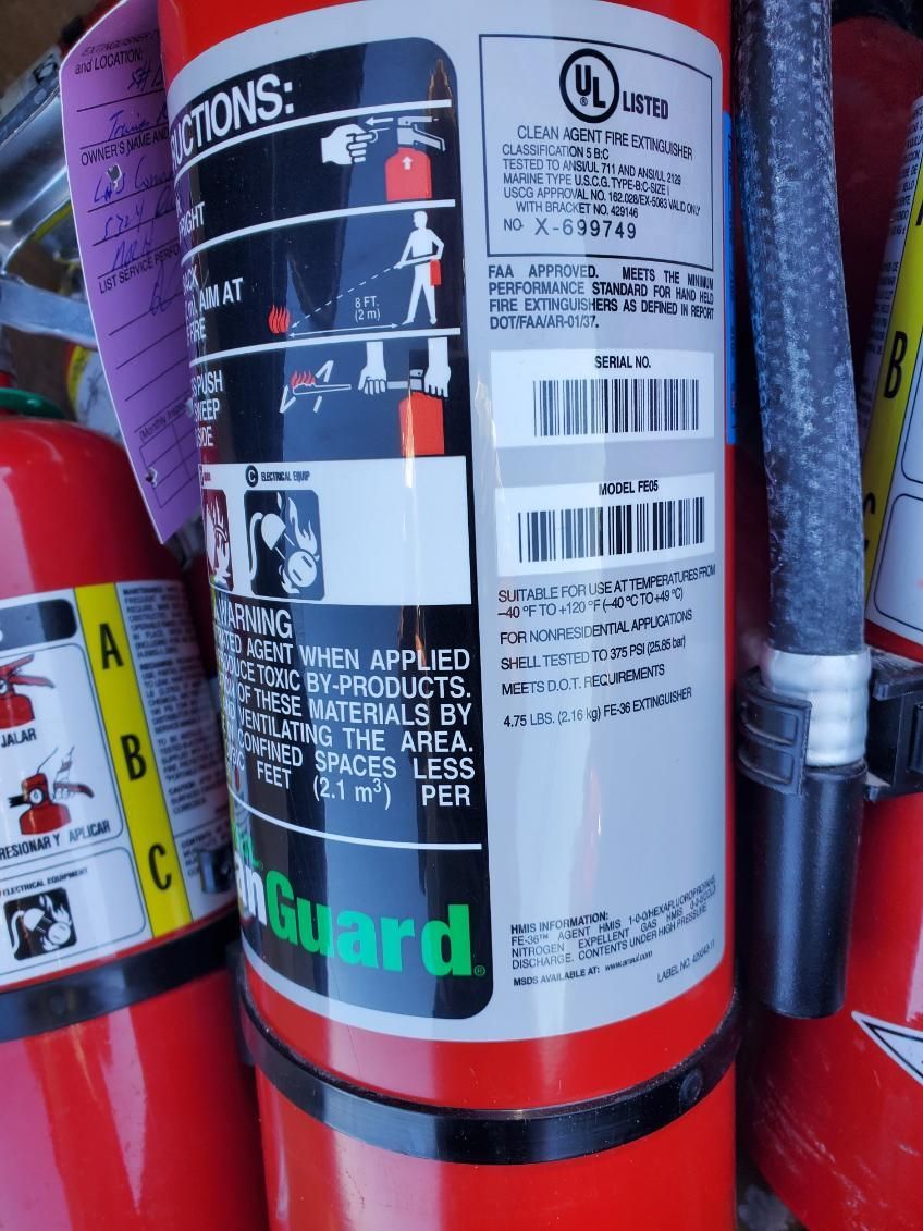 Red fire extinguisher mounted on a concrete pillar.