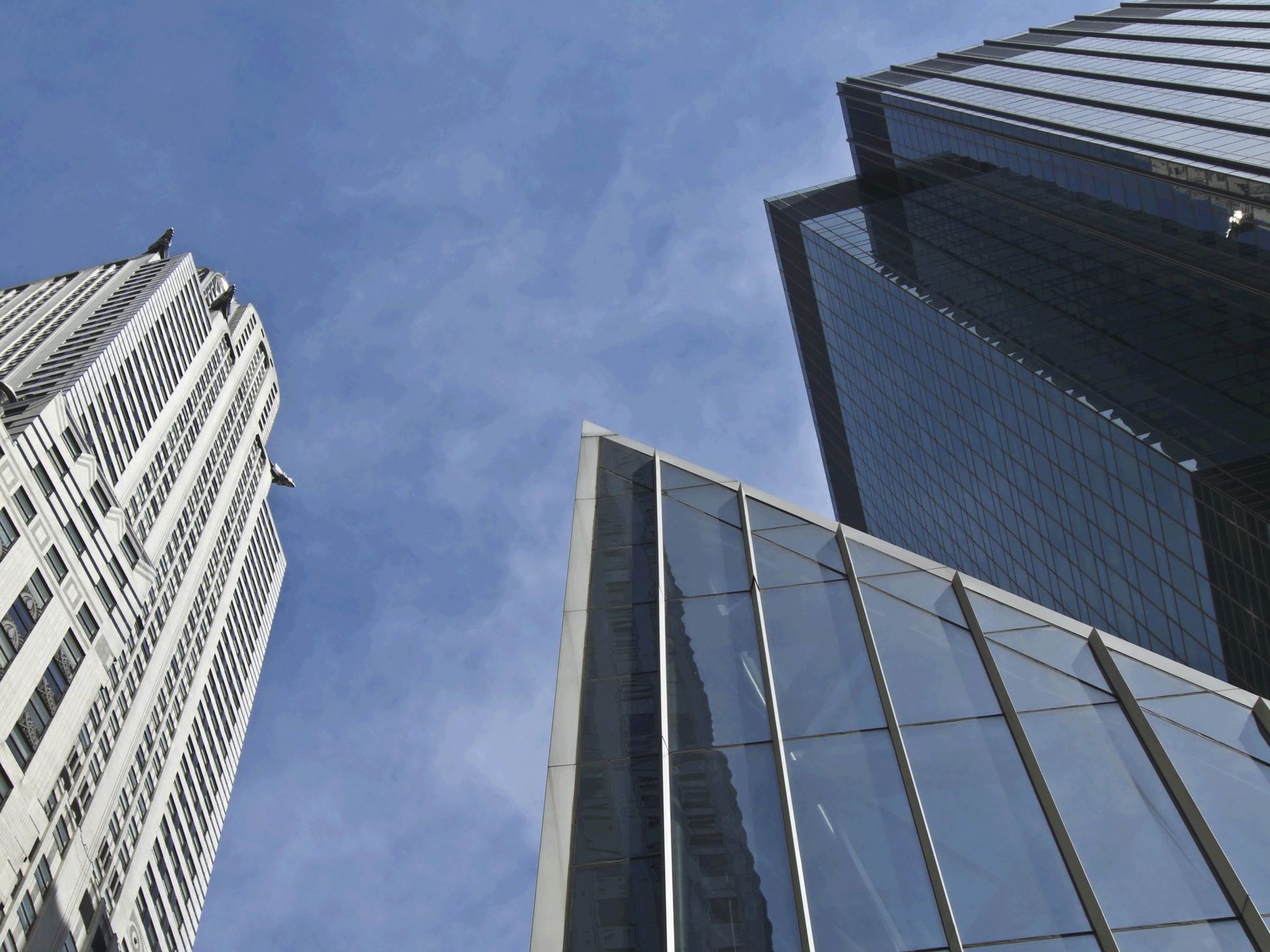 Skyscrapers with glass facades against a blue sky.