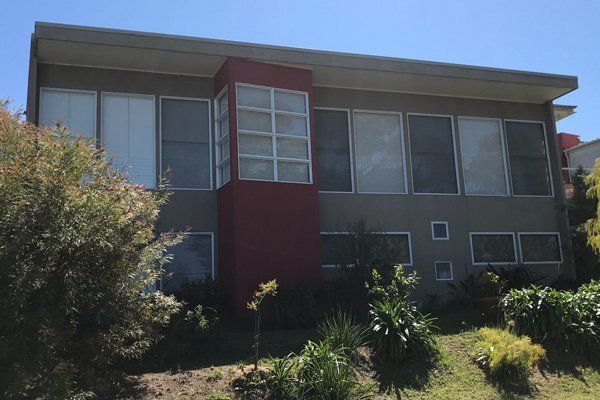 A large building with a lot of windows and trees in front of it